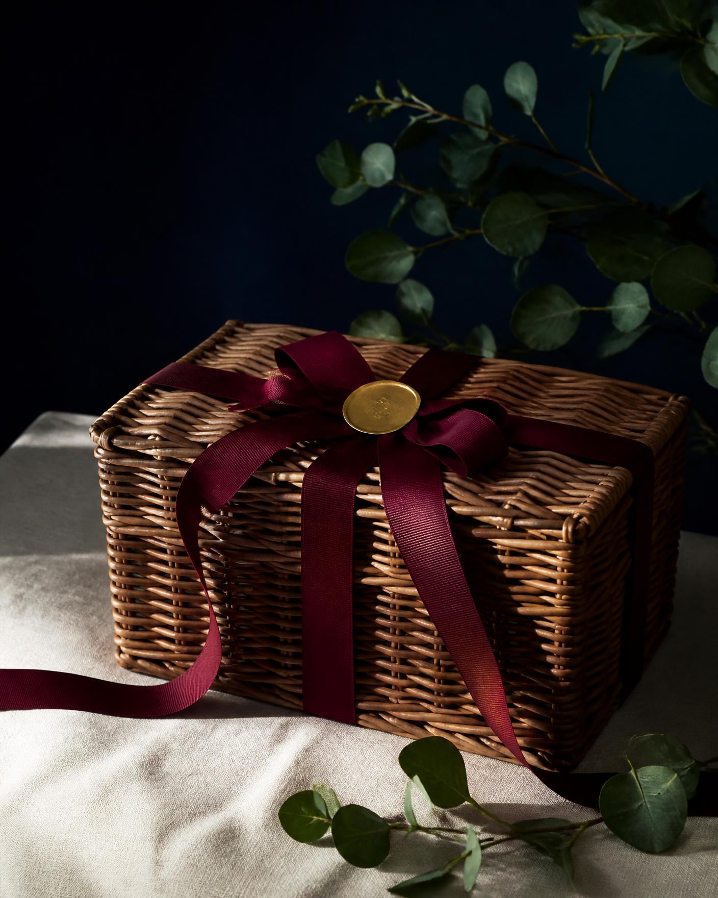 A wicker hamper tied with oxblood ribbon